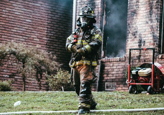 A firefighter walks away from the aftermath of a residential blaze.