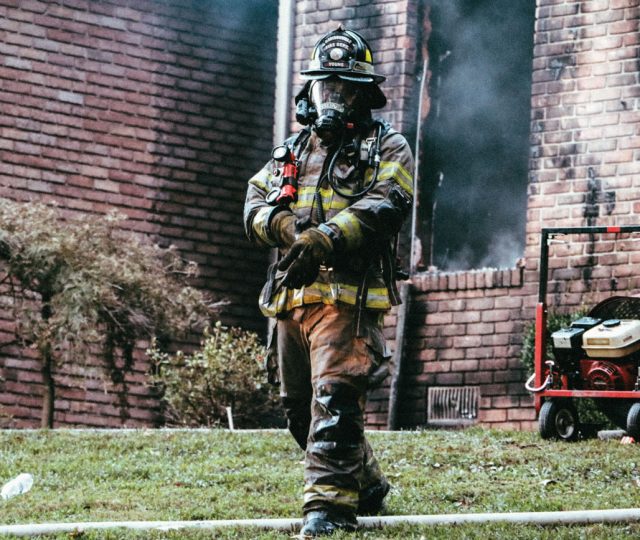 A firefighter walks away from the aftermath of a residential blaze.