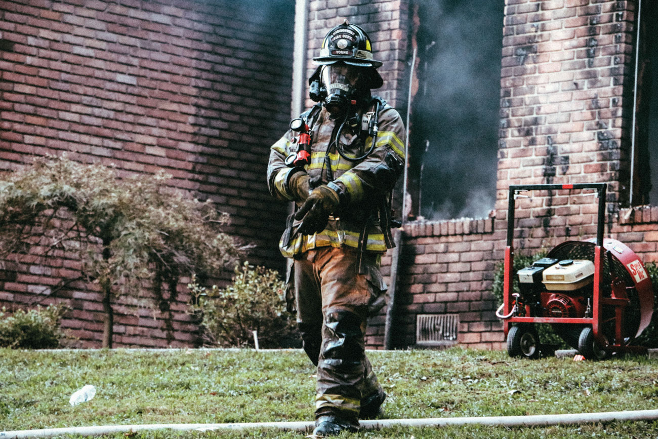 A firefighter walks away from the aftermath of a residential blaze.