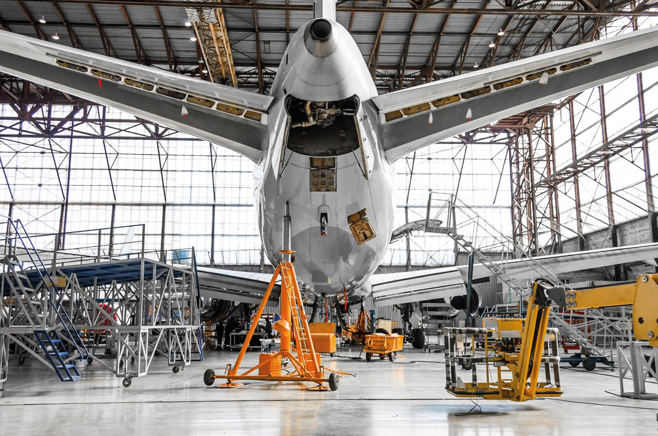 Aircraft in a hangar looking at an auxiliary power unit (APU).