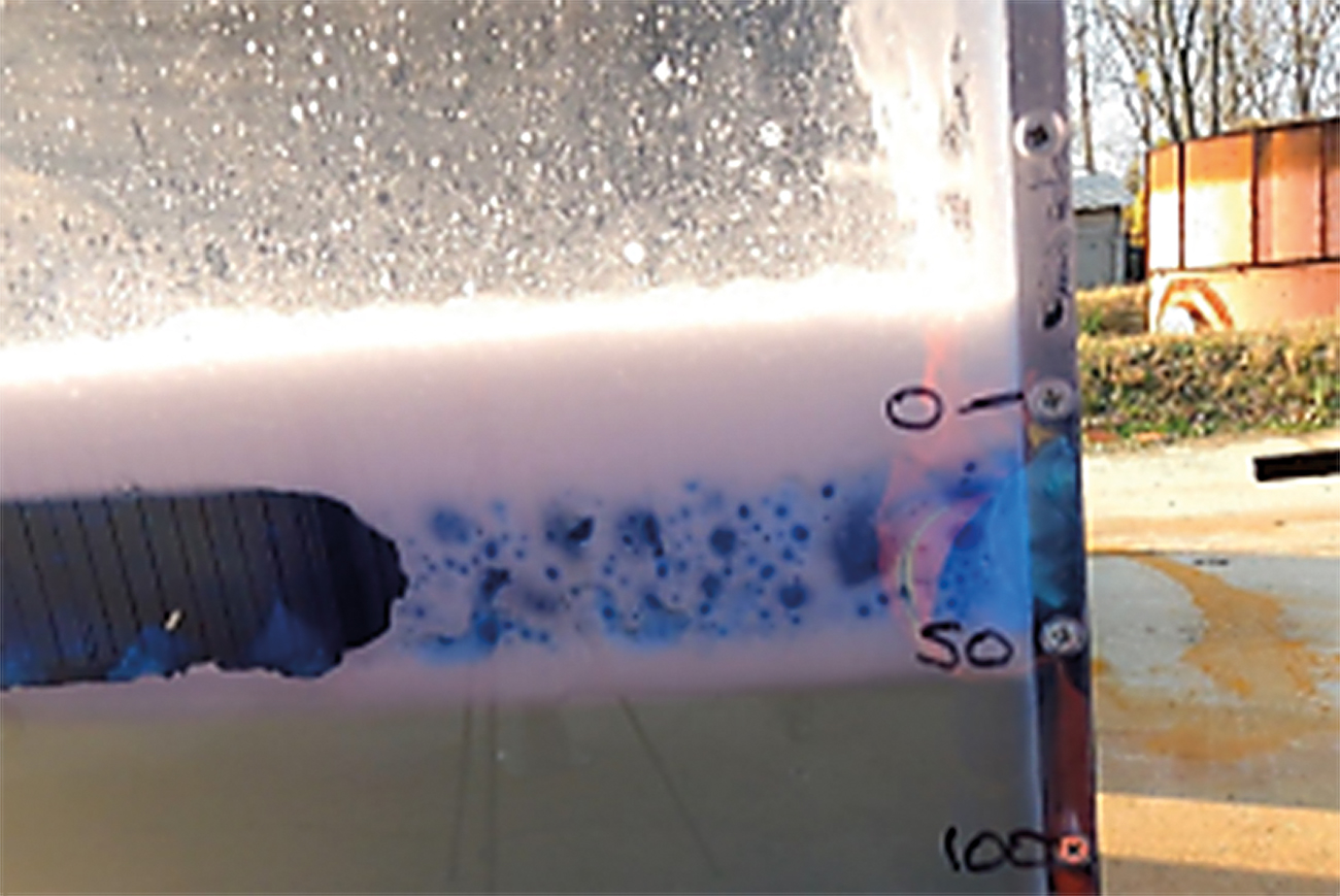 Figure 2. Side view of foam from a pourer plunging through 50mm of fuel. Note foam in the fuel. Images supplied by Author / Contributor
